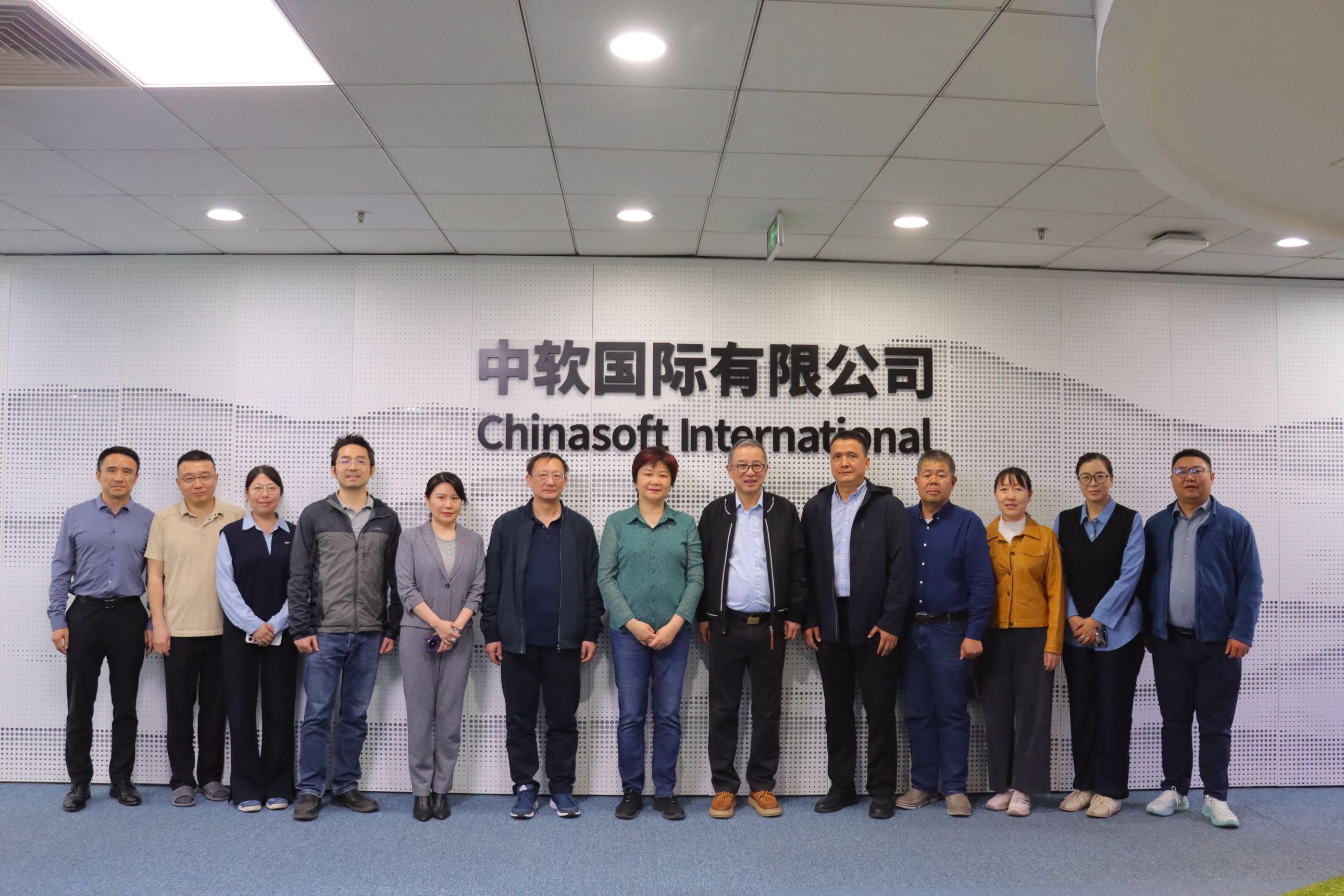 北京理工大学领导与中软国际高管在中软国际背景墙前合影